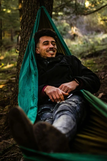 a man laying in a hammock in the woods, pexels contest winner, renaissance, mutahar laughing, profile image, enes dirig, shy smile