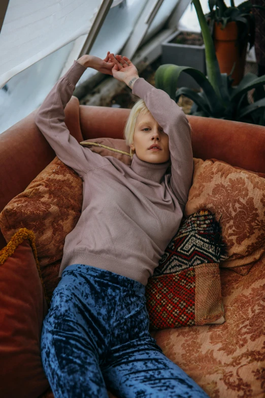 a woman that is laying down on a couch, trending on pexels, renaissance, wearing turtleneck, aurora aksnes, paisley, corduroy