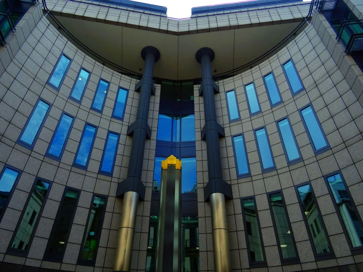 a tall building with a yellow arrow sticking out of it's side, inspired by Zaha Hadid, berlin secession, rotunda, channel 4, symmetrical front view, from the outside it looks folksy