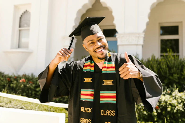 a man in a graduation cap and gown giving a thumbs up, unsplash, african aaron paul, ethiopian, embroidered robes, bay area