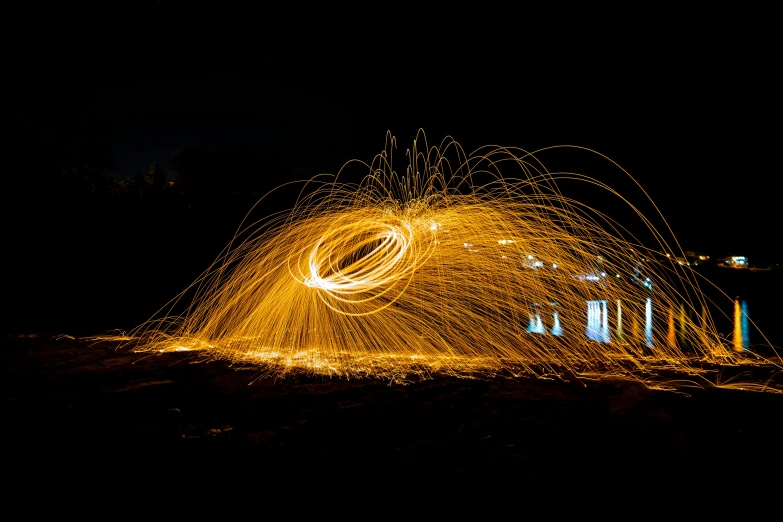 a steel wool spinning in the dark, by Sebastian Spreng, pexels contest winner, orange halo, gold glow, outdoor photo