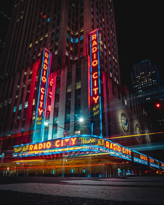 the radio city building is lit up at night, poster art, pexels contest winner, instagram photo, photograph taken in 2 0 2 0, color film photography, tail lights
