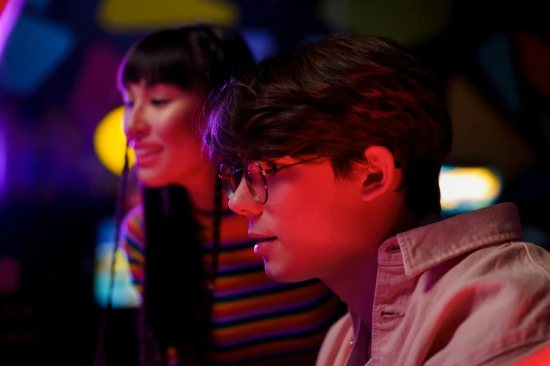 a couple of people that are sitting in front of a computer, an album cover, inspired by Liam Wong, pexels, a busy arcade, john egbert, closeup portrait shot, multiple lights