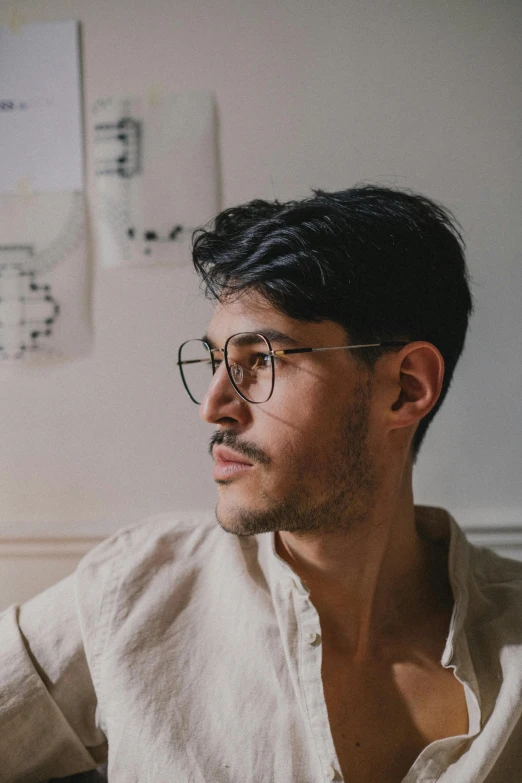 a man sitting in front of a laptop computer, a character portrait, inspired by Camilo Egas, trending on unsplash, square rimmed glasses, mark edward fischbach, androgynous male, profile shot