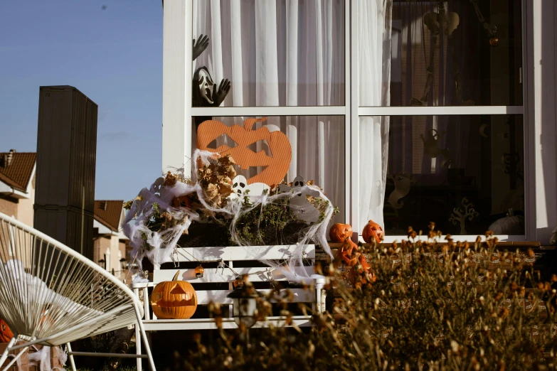 a white chair sitting in front of a window, a cartoon, by Julia Pishtar, pexels contest winner, halloween decorations, window with flower box, parade floats, balcony