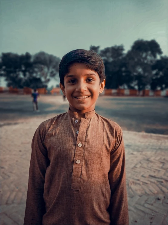 a young boy standing in the middle of a road, pexels contest winner, samikshavad, with a orientalist smileful face, 15081959 21121991 01012000 4k, portrait soft low light, brown