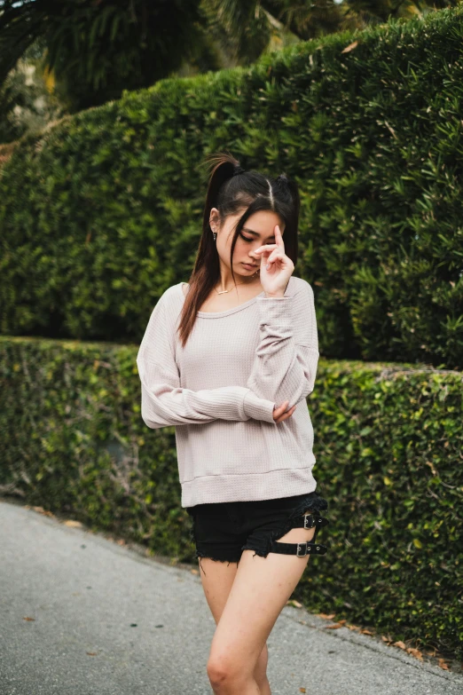 a woman walking down a street talking on a cell phone, by Robbie Trevino, unsplash, off the shoulder shirt, asian girl, pink and grey muted colors, round thighs