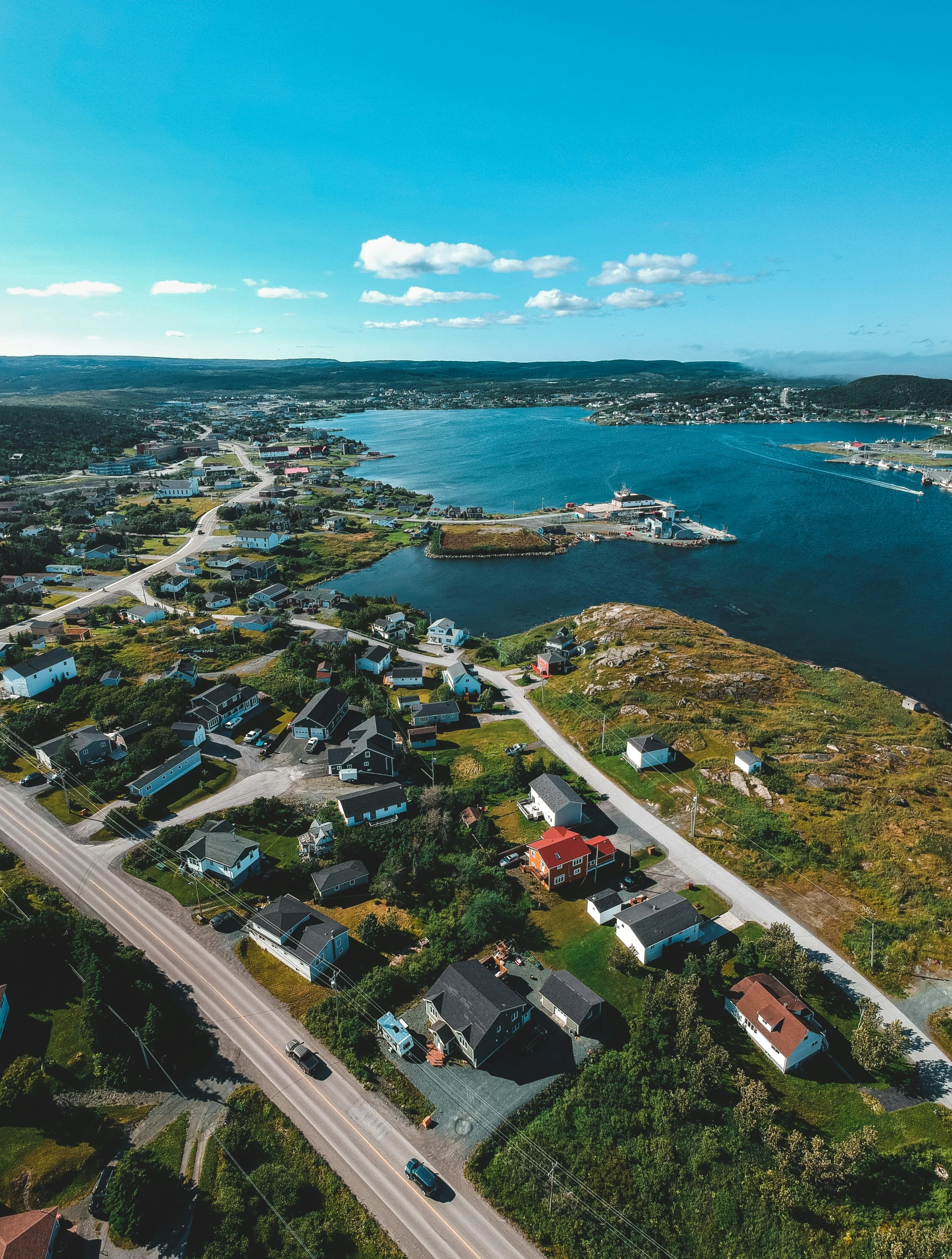 a large body of water surrounded by land, a picture, by Roar Kjernstad, pexels contest winner, houses and roads, harbour in background, slide show, drone footage