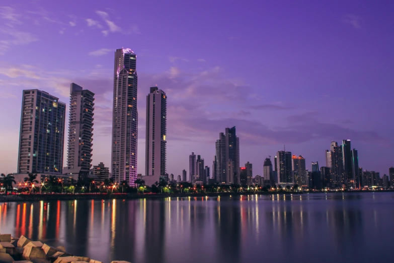 a large body of water surrounded by tall buildings, pexels contest winner, purple sky, gold coast australia, colombia, three towers