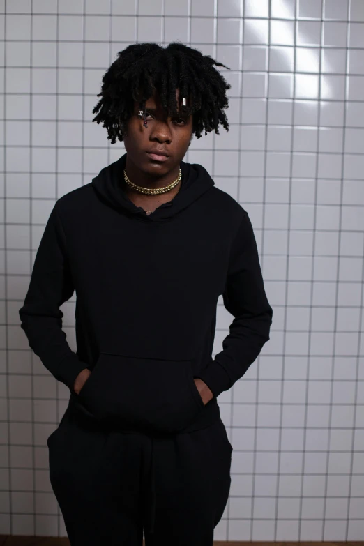 a man with dreadlocks standing in a bathroom, an album cover, inspired by Xanthus Russell Smith, unsplash, black hoodie, l · lawliet, plain background, black teenage boy