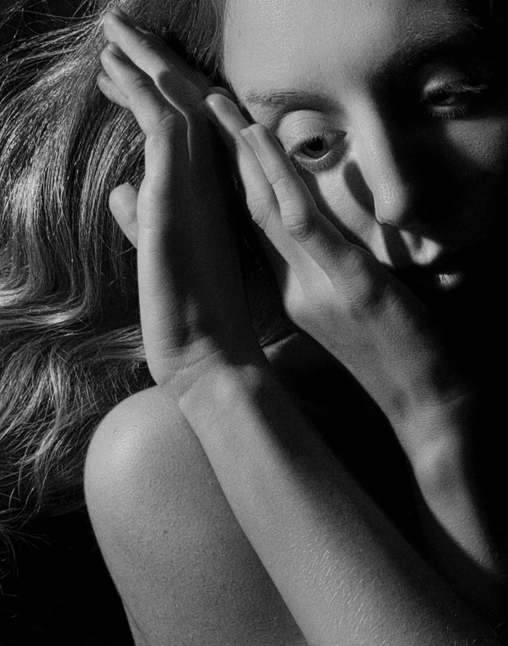 a black and white photo of a woman with her hands on her face, a black and white photo, inspired by Peter Basch, pexels contest winner, alternate album cover, close up of a blonde woman, mert and marcus, trapped in my conscious