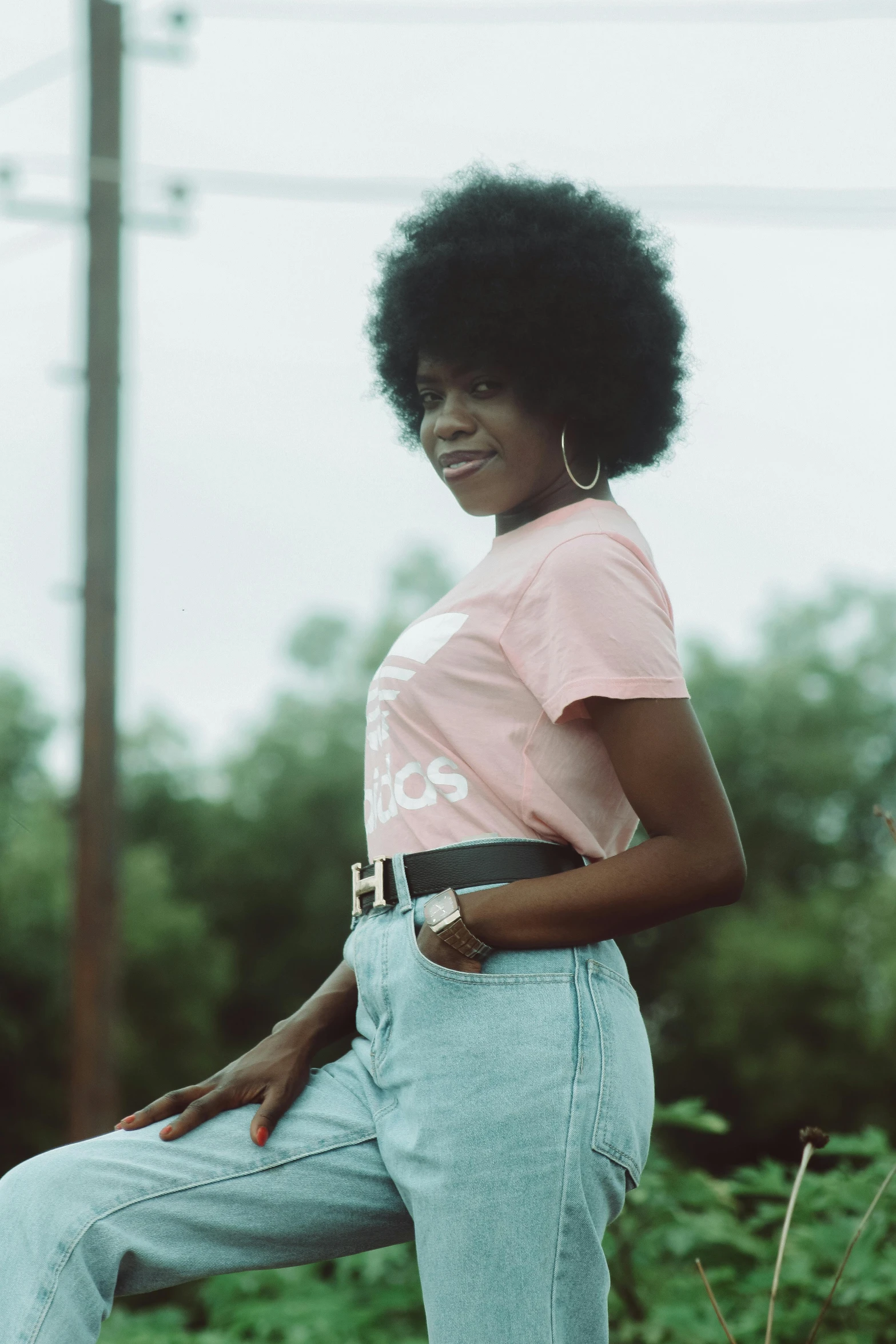 a woman in a pink shirt and jeans posing for a picture, an album cover, by Lily Delissa Joseph, pexels contest winner, afro tech, trending on vsco, profile image, graphic tees