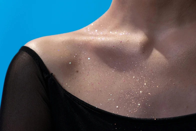 a close up of a woman with glitter on her chest, an album cover, inspired by Elsa Bleda, trending on pexels, freezing blue skin, clemens ascher, natural starlight, ink on skin