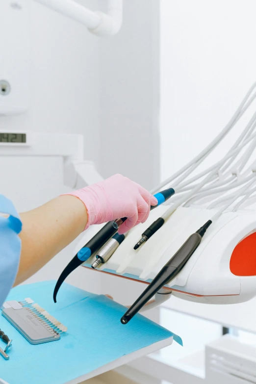 a close up of a person in a dentist's chair, handling laboratory equipment, holding knife, profile image, thumbnail