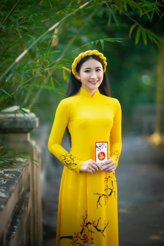 a woman in a yellow dress posing for a picture, inspired by Tang Di, happening, ao dai, avatar image, square, 8 k 4 k