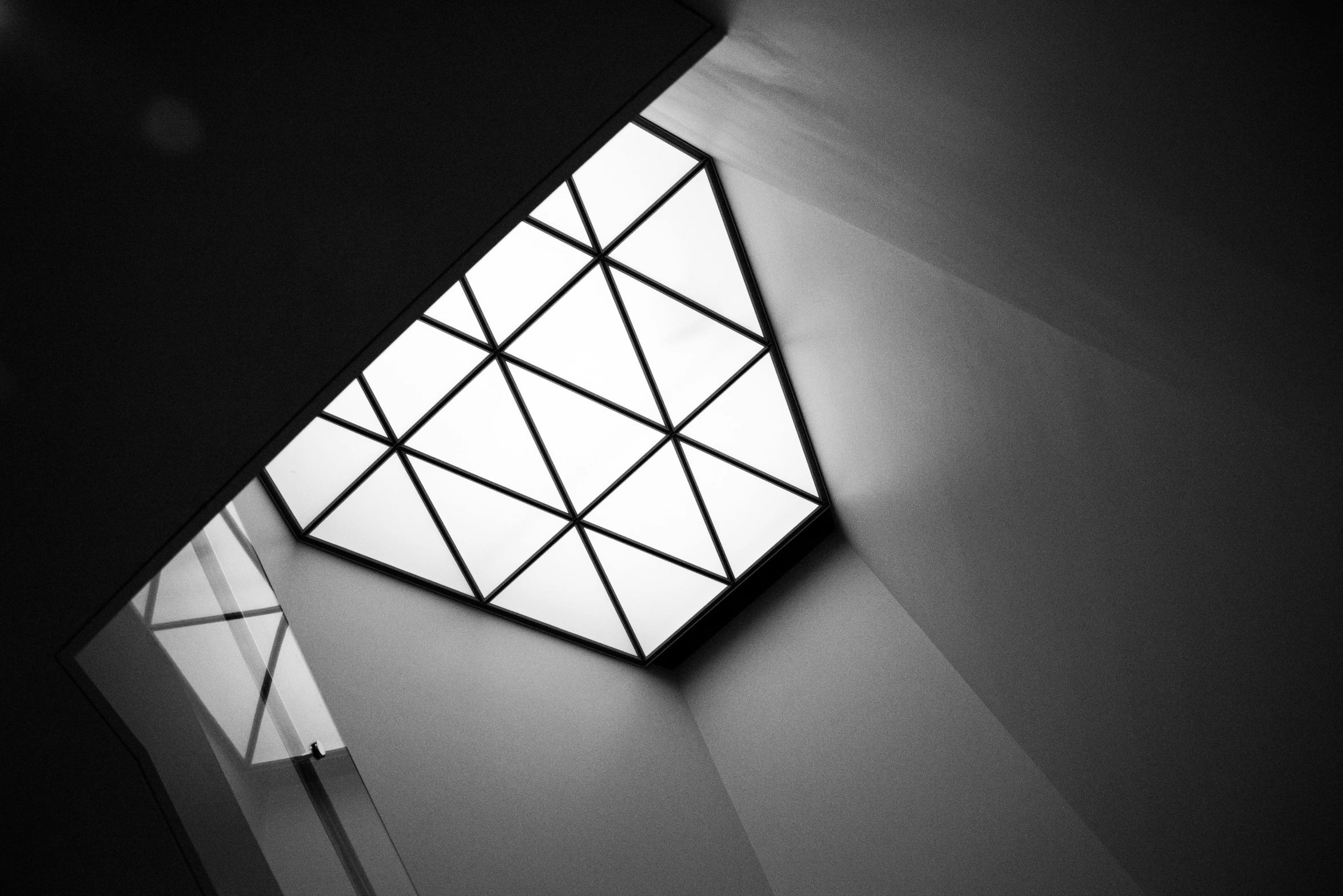 a black and white photo of a window in a building, by Karl Buesgen, light and space, triangles, fluorescent ceiling lights, square, beautiful light