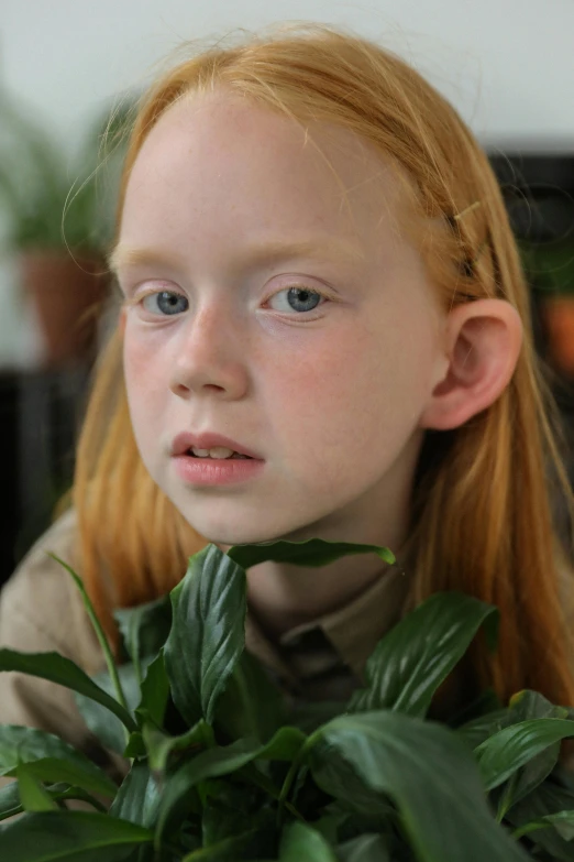 a young girl holding a plant in front of her face, inspired by Gerrit Dou, trending on unsplash, hyperrealism, red haired teen boy, video still, patricia piccinini, headshot profile picture