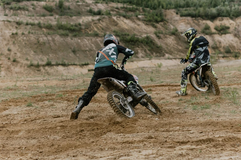 two people riding dirt bikes on a dirt track, a picture, unsplash, figuration libre, tournament, 🚿🗝📝, profile image, schools