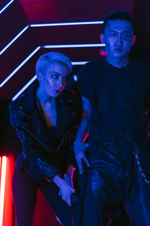 two people standing next to each other in front of neon lights, inspired by Wang Duo, trending on pexels, neoism, leather clothing, cai xukun, badass pose, alien room
