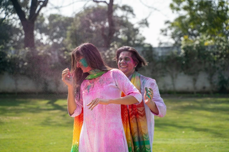 a couple of women standing on top of a lush green field, pexels contest winner, color field, wearing a silk kurta, woman crying rainbow paint, wearing a fancy dress, pink