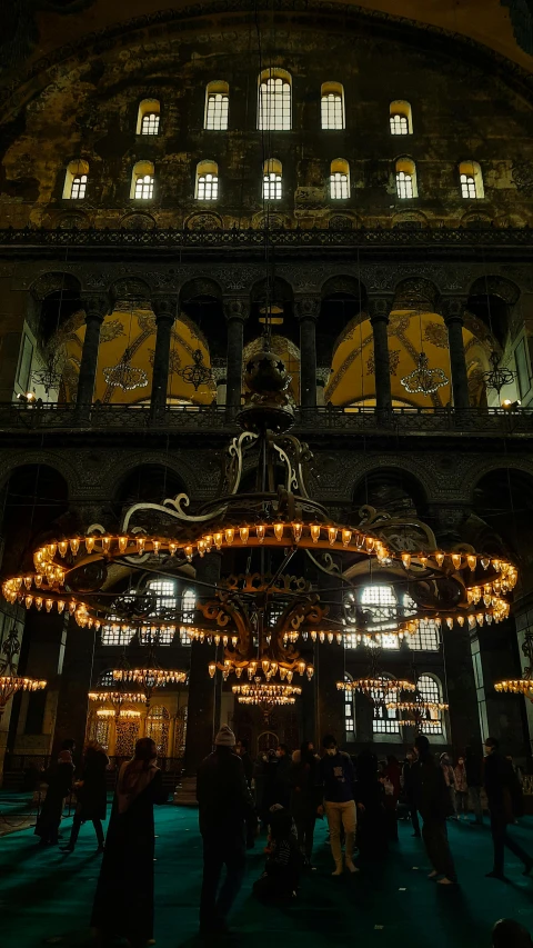 a group of people standing in front of a building, trending on unsplash, art nouveau, church chandelier, byzantine, lights inside, turkey