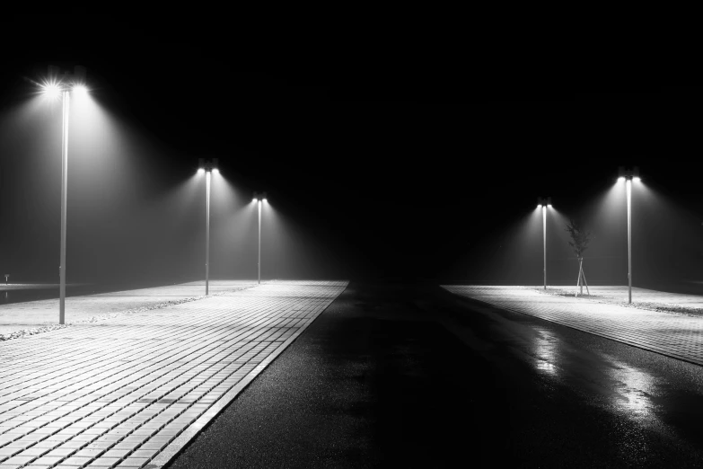 a black and white photo of a street at night, a black and white photo, by Gusztáv Kelety, unsplash contest winner, postminimalism, volume raytracing fog, minimalistic art, lamps on ground, unsplash photo contest winner