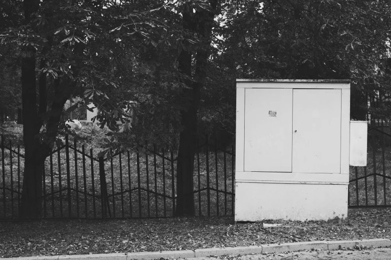 a black and white photo of a refrigerator in front of a fence, a black and white photo, by Emma Andijewska, forest city streets behind her, фото девушка курит, shot on iphone 6, photographic print