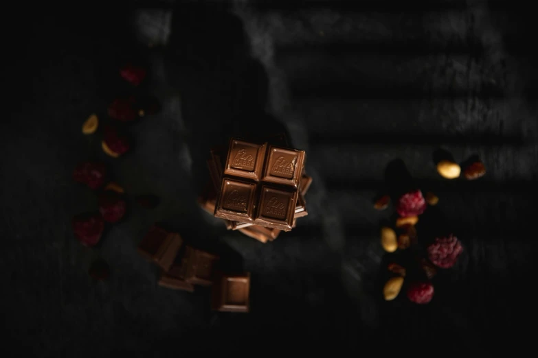a piece of chocolate sitting on top of a table, a still life, pexels contest winner, in the dark, cubes on table, 15081959 21121991 01012000 4k, instagram post