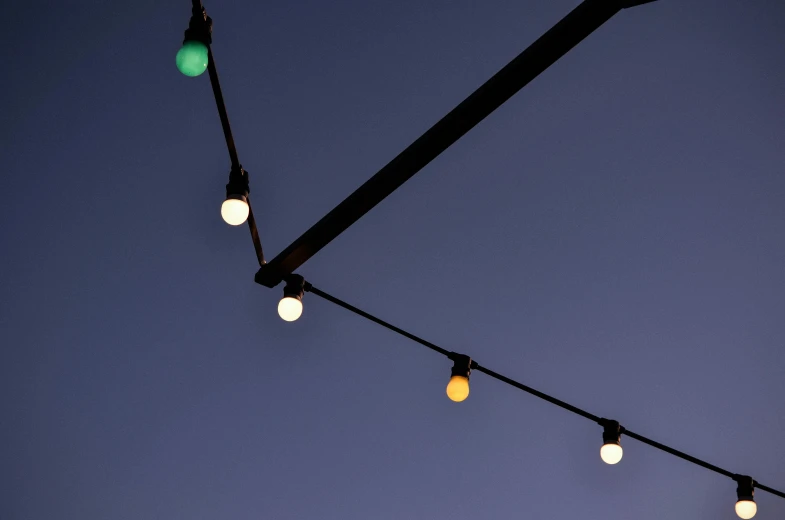 a string of lights against a blue sky, inspired by Cerith Wyn Evans, minimalism, outdoor lighting, multicoloured