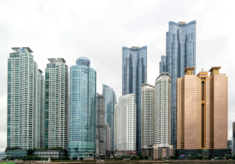 a group of tall buildings next to a body of water, by Jang Seung-eop, pexels contest winner, hyperrealism, shenzhen, white marble buildings, compact buildings, 2000s photo