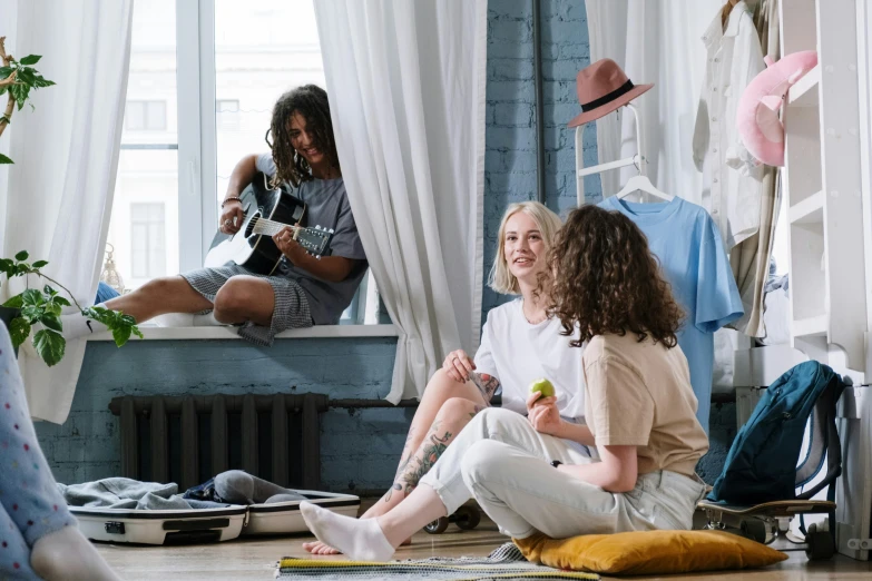 two women sitting on the floor in front of a window, pexels contest winner, happening, women playing guitar, someone in home sits in bed, people on a picnic, in suitcase