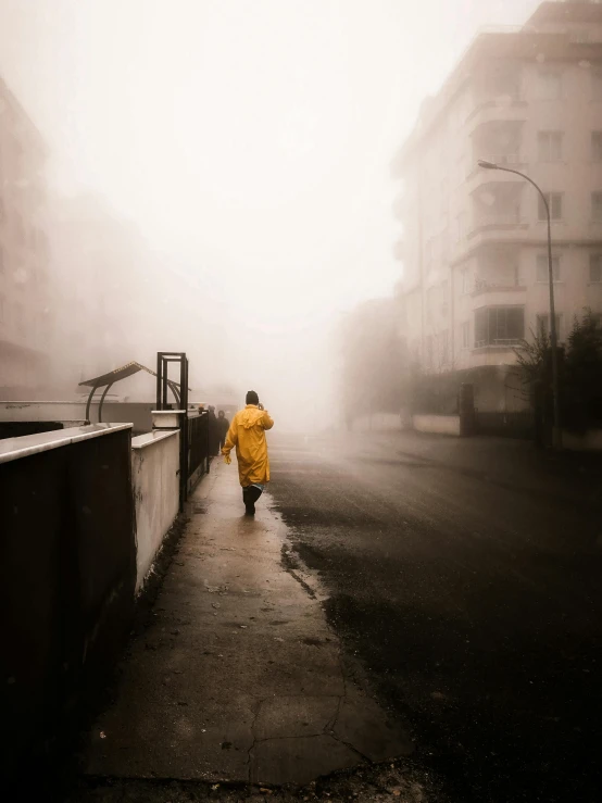 a person walking down a street on a foggy day, by irakli nadar, yellow robe, plain, ((mist)), heavy rainy