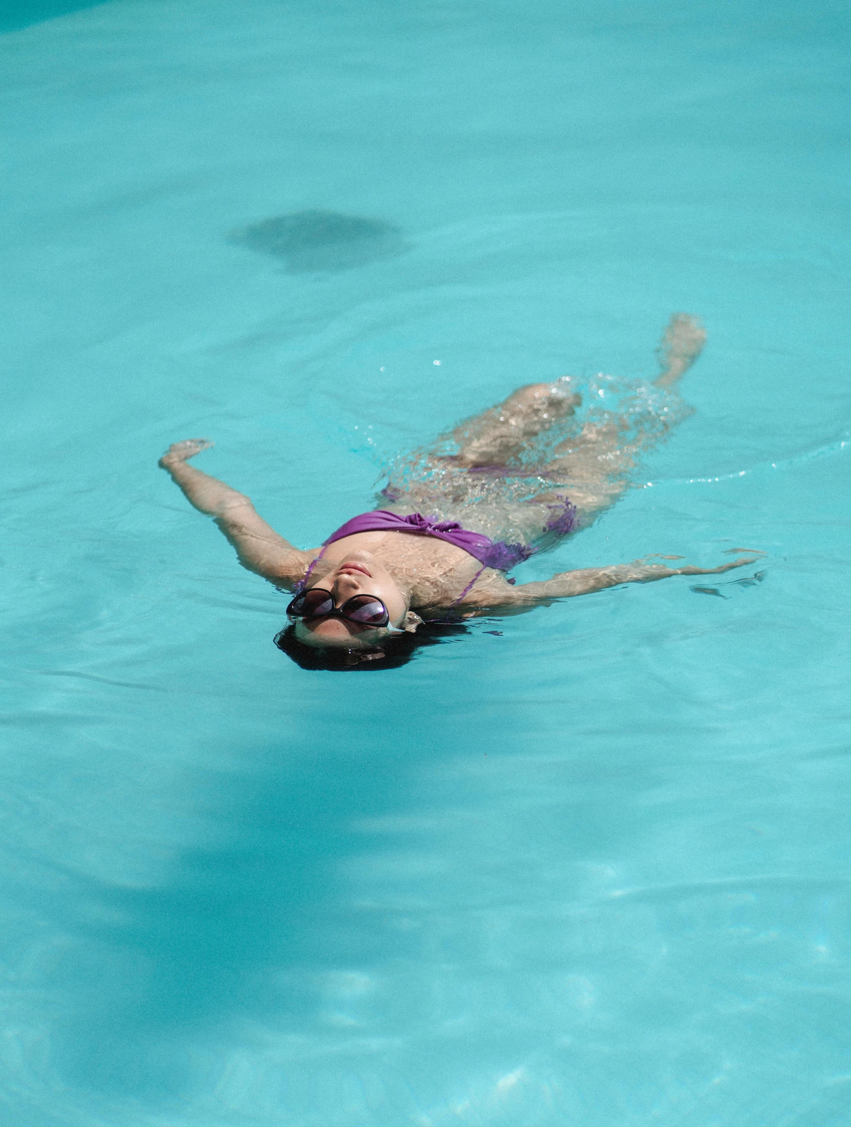 a woman in a purple bikini swims in a pool, inspired by Eric Zener, pexels contest winner, wearing goggles, profile image, full body pose, family friendly