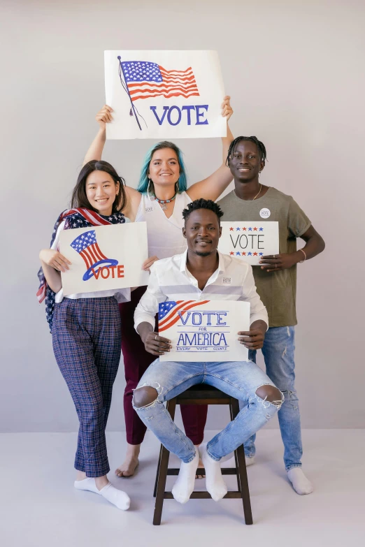 a group of people holding signs that say vote, a photo, trending on pexels, renaissance, fullbody photo, american total portrait, proud, four hands