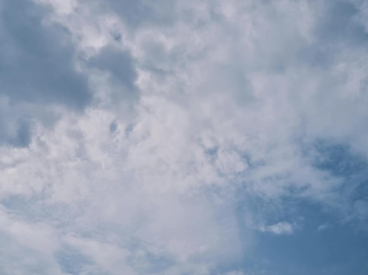 a person flying a kite on a cloudy day, unsplash, minimalism, layered stratocumulus clouds, low angle 8k hd nature photo, light blues, low quality footage