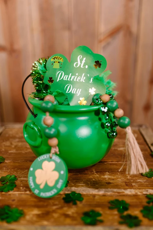 a green pot sitting on top of a wooden table, clover, green tones and golden charms, brightly lit!, full product shot