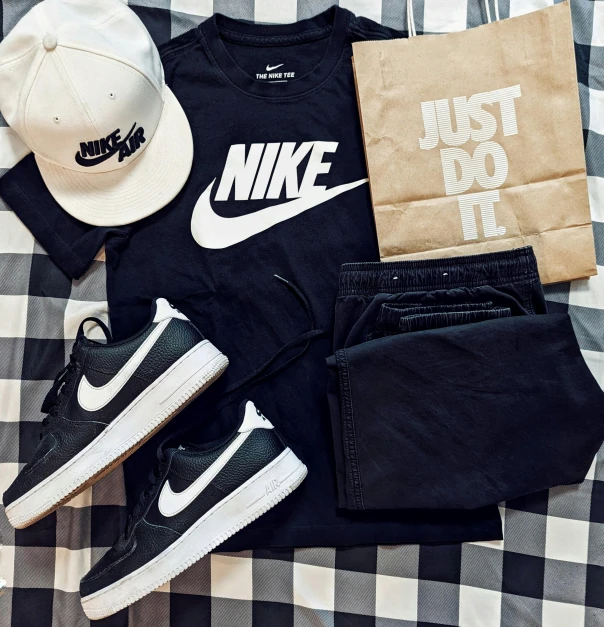 a hat, t - shirt, sneakers, and a bag are laid out on a bed, instagram, nike shirt, black in, 🚿🗝📝