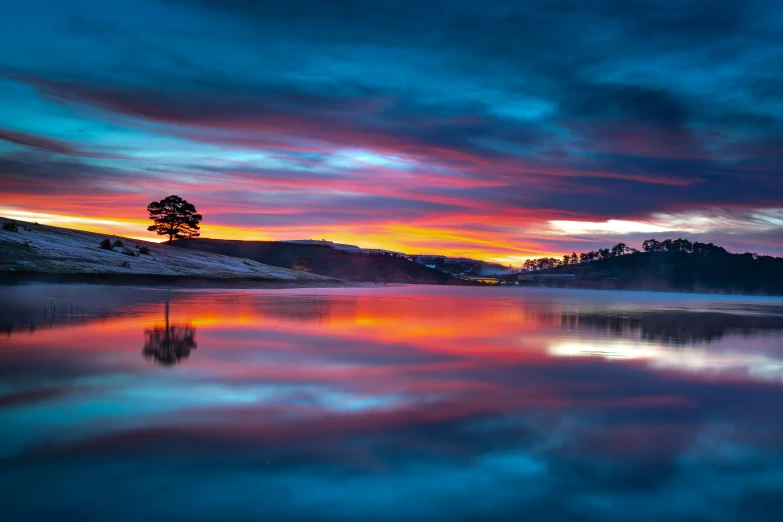 a lake with a tree in the middle of it, by Lee Loughridge, pexels contest winner, colorful sunset, australian winter night, sunset in a valley, red and blue reflections