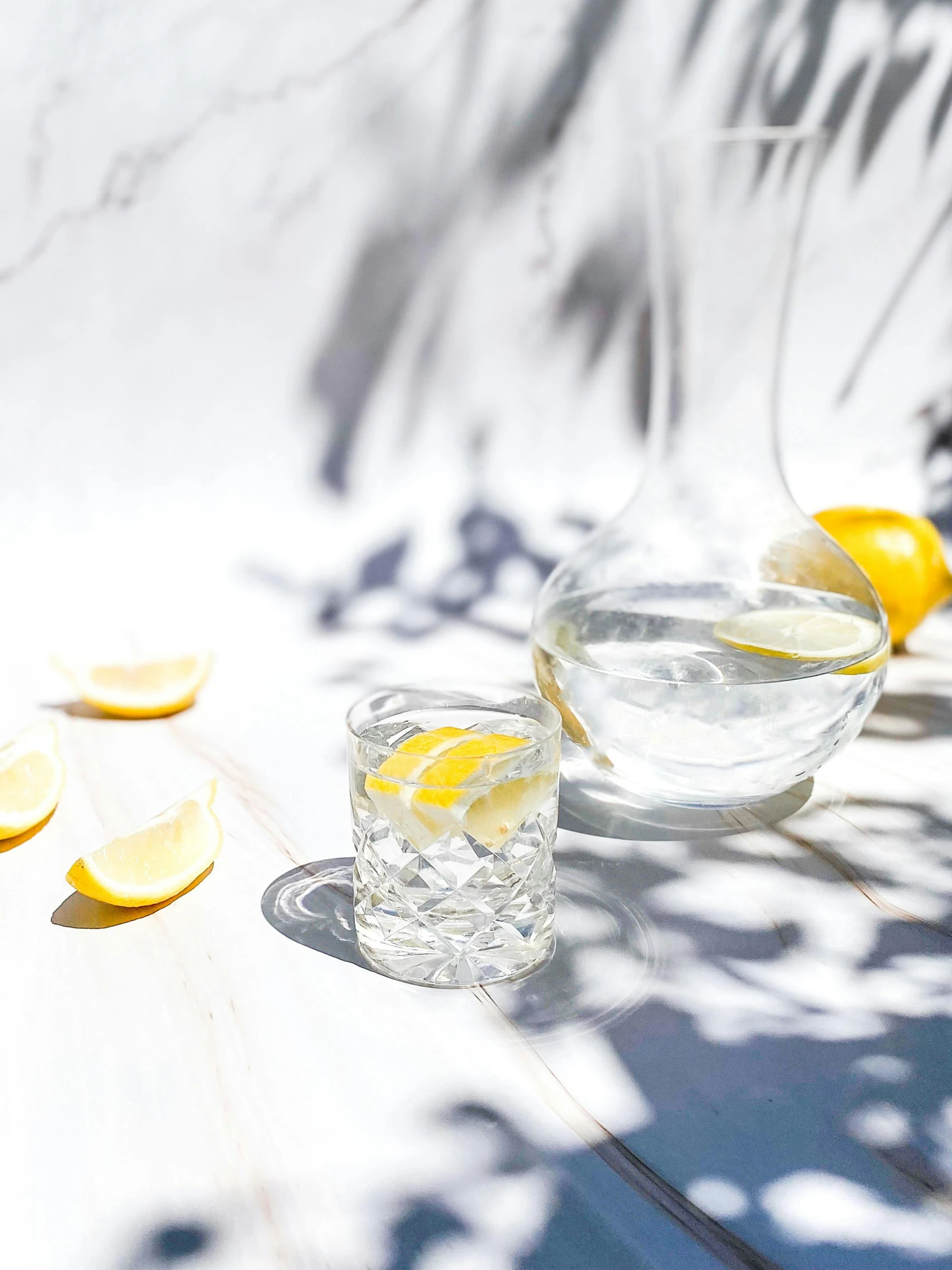 a couple of glasses sitting on top of a table, with lemon skin texture, crystal water, beautifully bright white, promo image