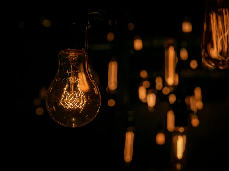 a bunch of light bulbs hanging from a ceiling, inspired by Bruce Munro, pexels contest winner, synthetism, brown atmospheric lighting, in a darkly lit laboratory room, electric wallpaper, gold dappled lighting