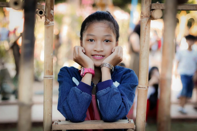 a young girl sitting on top of a wooden chair, pexels contest winner, sumatraism, avatar image, small chin, 1 6 years old, nivanh chanthara