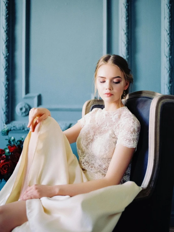 a woman in a white dress sitting in a chair, inspired by Emma Ríos, trending on unsplash, baroque, soft flawless pale skin, wedding dress, 15081959 21121991 01012000 4k, embroidered velvet