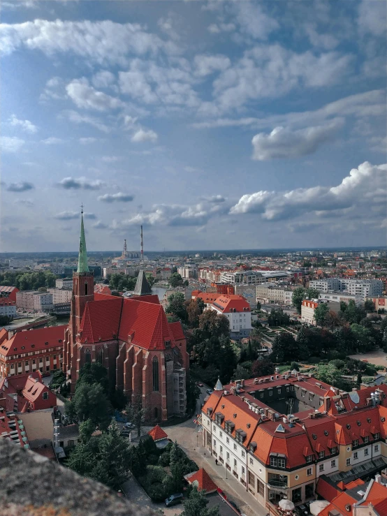 a view of a city from the top of a building, by Adam Marczyński, pexels contest winner, red castle in background, spire, 1999 photograph, color image