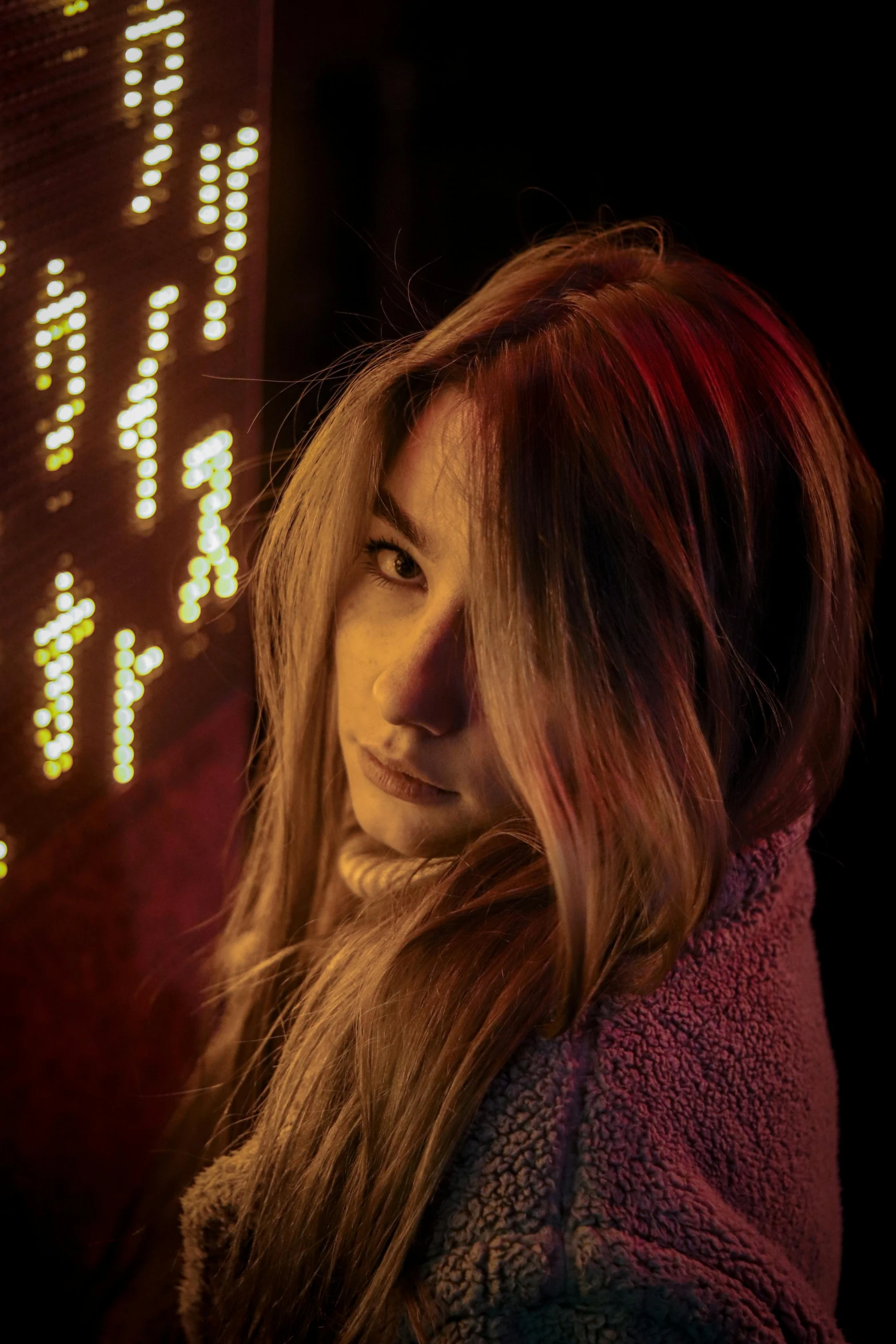 a woman standing in front of a neon sign, a portrait, inspired by Elsa Bleda, trending on pexels, dark blonde long hair, ana de armas portrait, grainy photo, backlighted