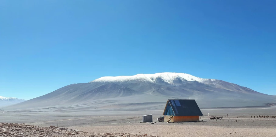 a small house in the desert with a mountain in the background, a photo, by Olivia Peguero, hurufiyya, glaciers and ice and snow, avatar image, chilean, high level