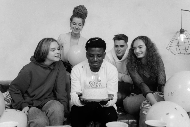 a group of people sitting around a birthday cake, a black and white photo, pexels, renaissance, black teenage boy, 9 0 - s fashion, 2 1 savage, 25 years old