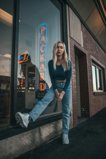 a woman standing in front of a store window, by Drew Tucker, pexels contest winner, photorealism, baggy jeans, portrait of billie eilish, blonde women, standing in a restaurant