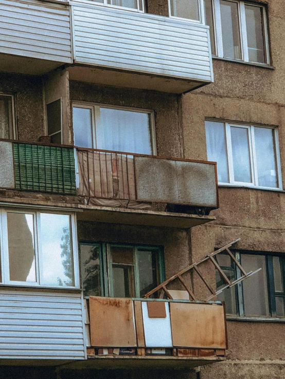 a very tall building with a bunch of windows, a photo, inspired by Elsa Bleda, pexels contest winner, brutalism, soviet suburbs, belongings strewn about, balcony scene, 2000s photo