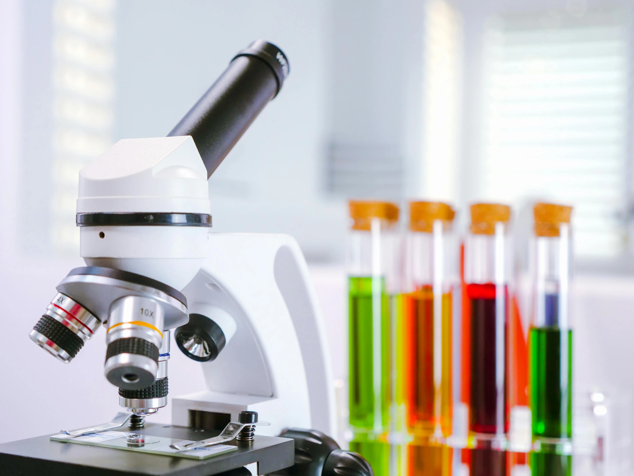 a microscope sitting on top of a table next to test tubes, a microscopic photo, shutterstock, a brightly coloured, schools, aesthetics, medical equipment