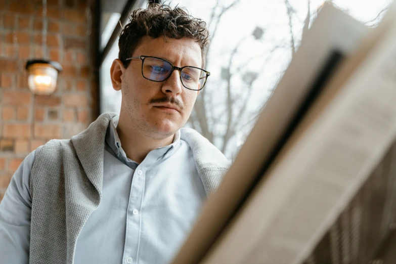 a man in glasses looking at a piece of paper, a photorealistic painting, by Adam Marczyński, trending on pexels, thick mustache, looking out window, julian ope, reading